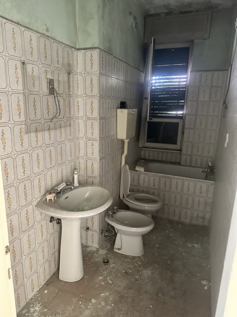 Vecchio bagno con lavabo e bidet da sostituire